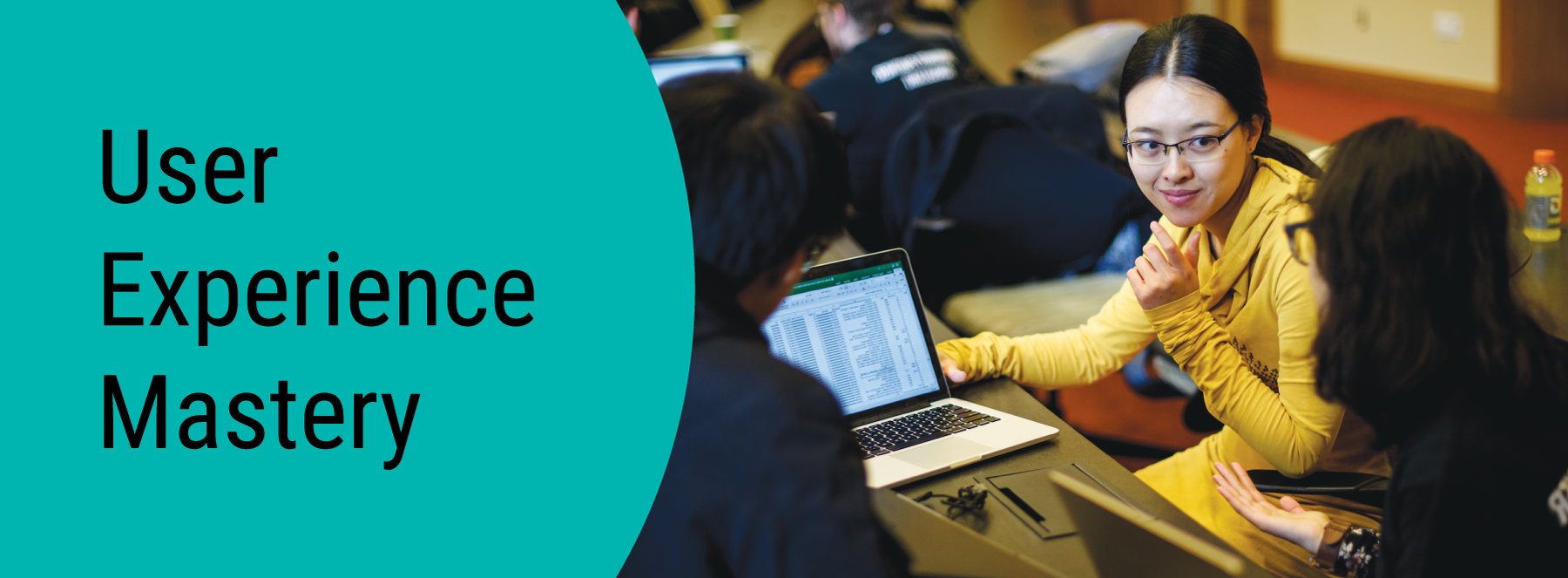 User Experience Mastery. Three students looking at a laptop together.