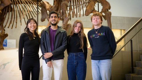 students stand next to a fossil