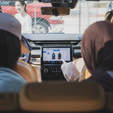 An interior view of a vehicle as two students interact with the in-vehicle interface