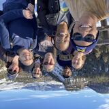 A selfie of eight individuals posing at an overlook in Yellowstone National Park