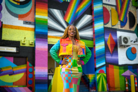 girl standing in front of abstract art wall display