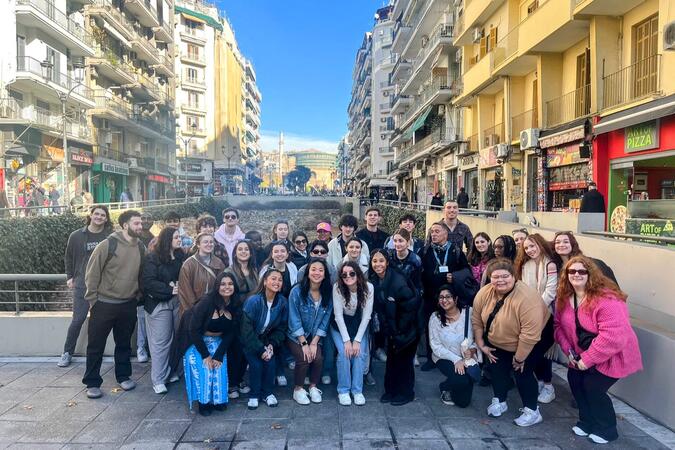 A group picture on a city street with a blue sky in the background.