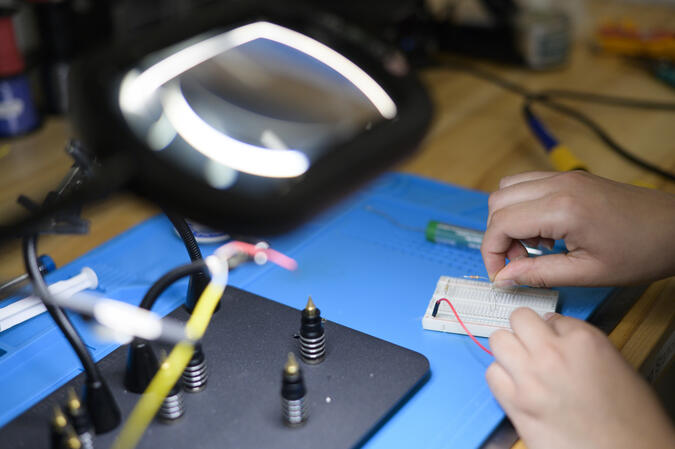 A person's hands connecting circuits.