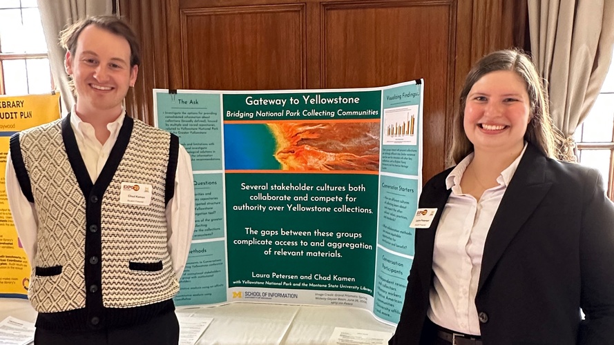 UMSI students Chad Kamen and Laura Peterson pose with the poster board for their project at the 2023 UMSI Student Project Exposition. Their project board is titled “Gateway to Yellowstone: Bridging National Park Collecting Communities.”