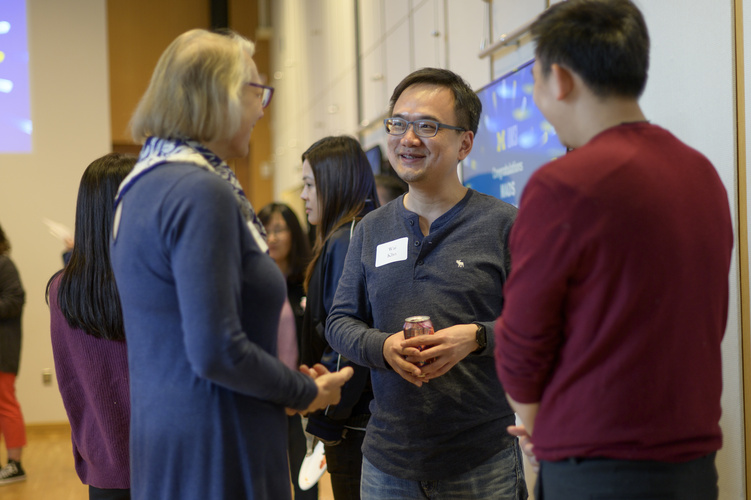 Students mingle in space 2435, a large event space