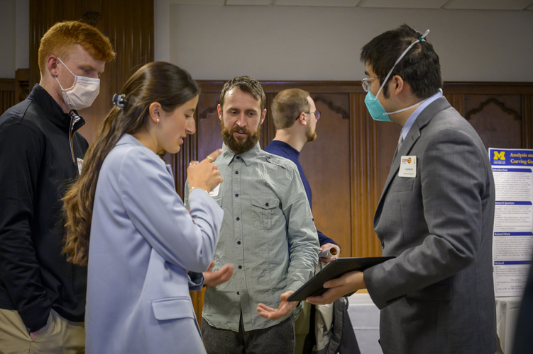 Students look over posters in a conference room