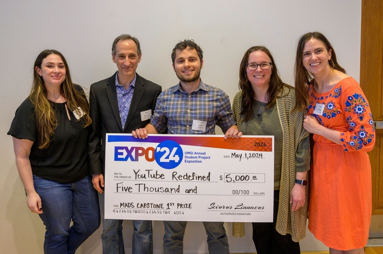 MADS students pose with Paul Resnick and Andrea Forte, holding a ceremonial check to celebrate their prize-winning Expo project.