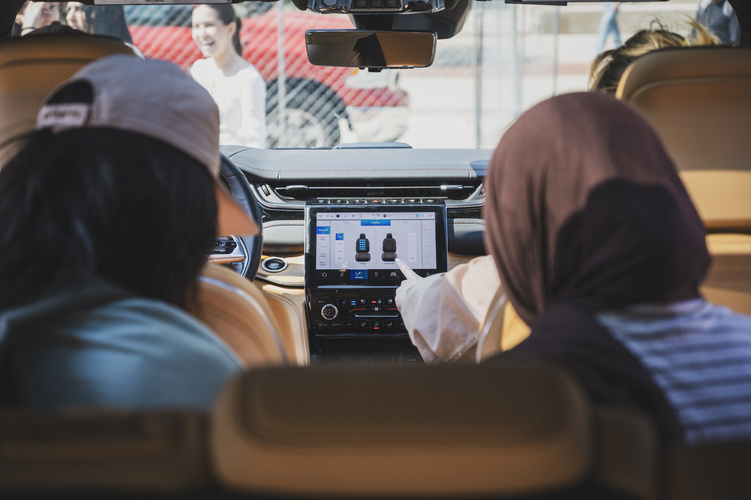 An interior view of a vehicle as two students interact with the in-vehicle interface