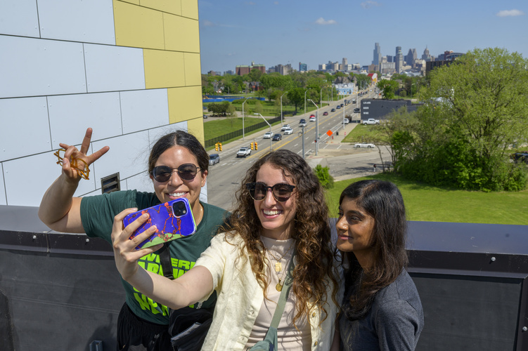 Three classmates pose for a selfie on the rooftop of the LOVE Building