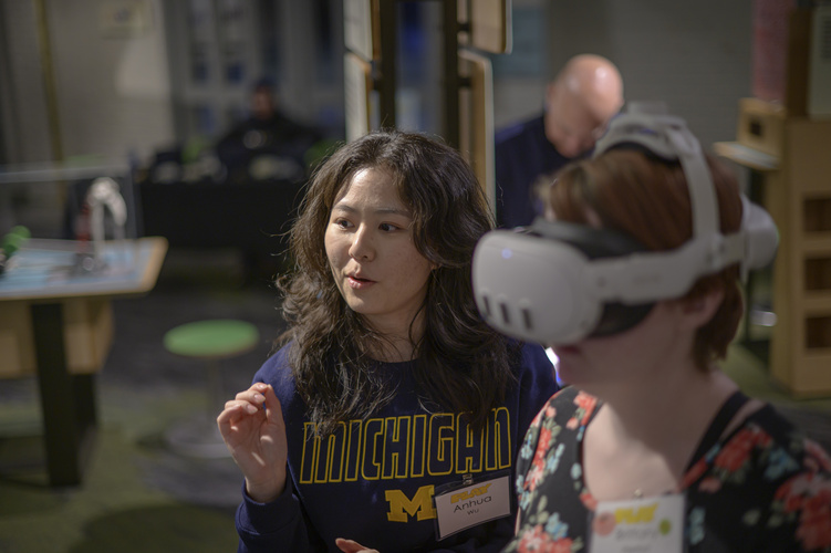 Anhua Wu gestures while speaking to a person in a headset