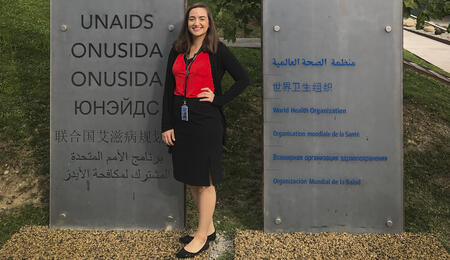Erin Cardwell next to a UNAIDS sign