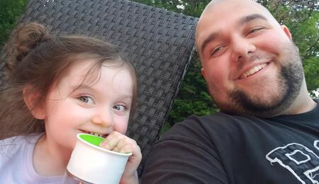 Matthew Wiese smiles next to his child