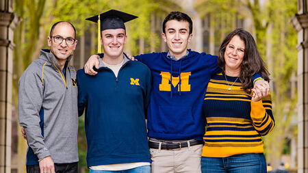 The Ehrenberg family smiling and dressed in U-M colors. 