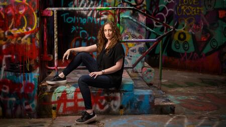 Michaelanne Thomas pictured in an alley with colorful graffiti