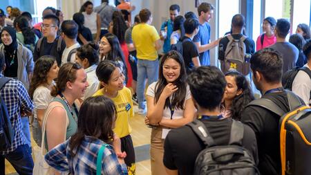 Students mingle in space 2435, a large event space