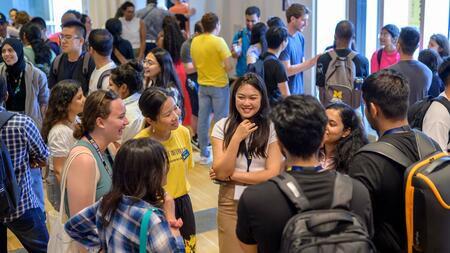 Students mingle in space 2435, a large event space