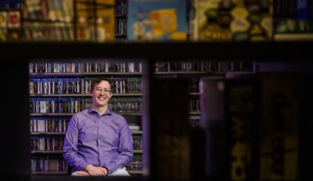 A photo of Clayton Zimmerman among the collection in the Computer and Video Game Archive