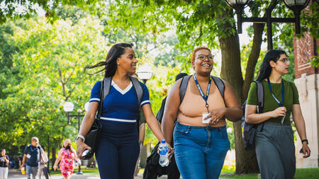 Students walk through the U-M campus near academic buildings on a tour.