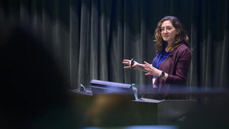 Abigail Jacobs gestures while speaking at a podium