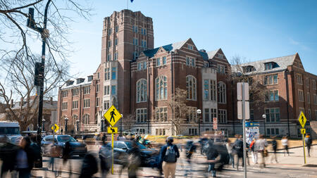 Students cross a busy State Street in front of The Michigan Union.
