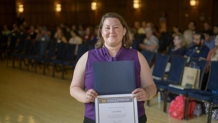 Carina Wilson poses holding an award.