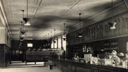A black and white photo of a circulation desk in the university library in the 1920s