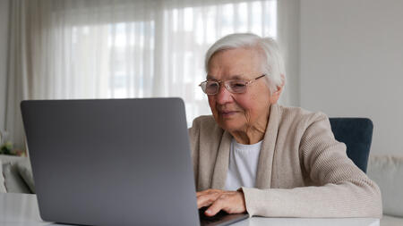 An elderly person using a laptop