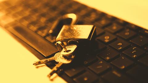 An unlocked padlock laying on a keyboard