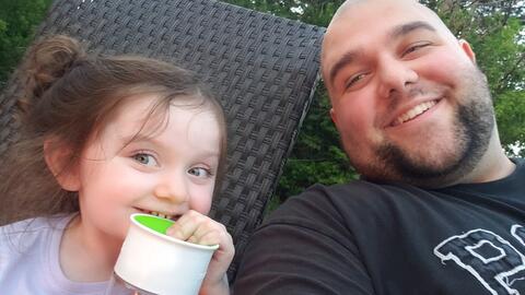 Matthew Wiese smiles next to his child