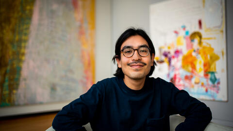 Master of Science in Information student Alexis Herrera seated among artworks at the University of Michigan Museum of Art.