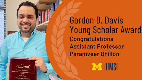 Paramveer Dhillon holding a plaque in his office. "Congratulations Assistant Professor Paramveer Dhillon, 2021 Gordon B. Davis Young Scholar Award recipient"