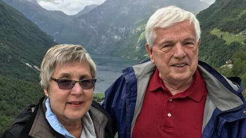 Nancy and Donald Bliss standing near mountains. 