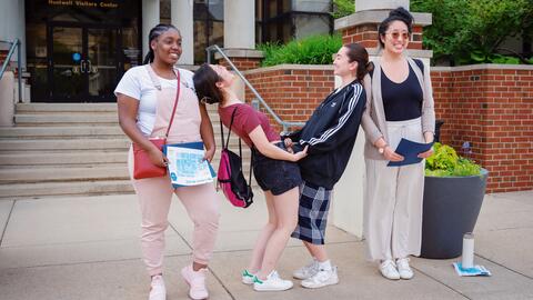 Community college students touring the U-M campus make the Michigan “M” by posing as different parts of the letter in front of the Huetwell Visitors Center.