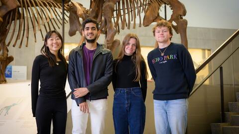 students stand next to a fossil