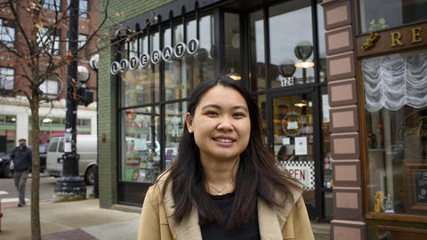 An Doan stands in front of a store facade on a street