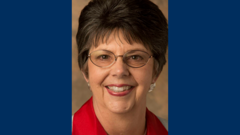 A portrait of Nancy Gwinn on a blue background