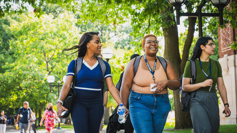 Students walk through the U-M campus near academic buildings on a tour.
