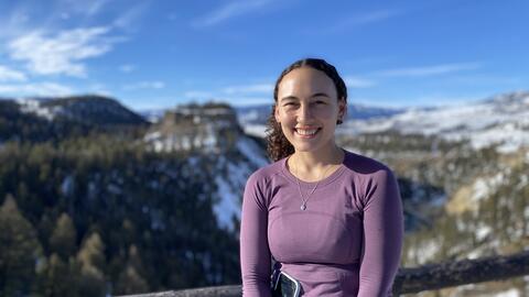 A portrait of Sarah Lancaster with a snow-covered valley behind her