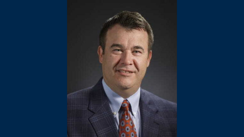 A headshot of Randy Riley with a dark blue background 