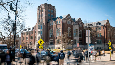 Students cross a busy State Street in front of The Michigan Union.