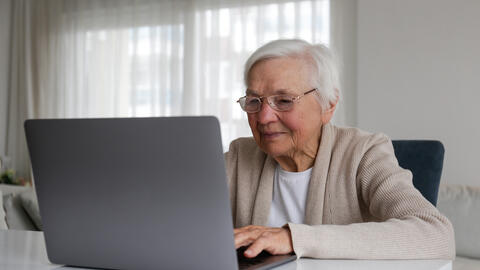 An elderly person using a laptop