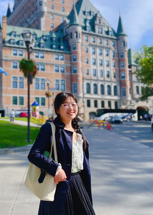 Nancy Xu posing in front of a large brick building