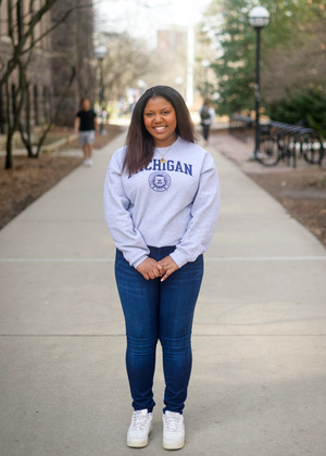 Ambar standing on a sidewalk on the diag