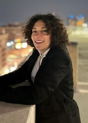 Noor Hindi smiling on top of a roof.