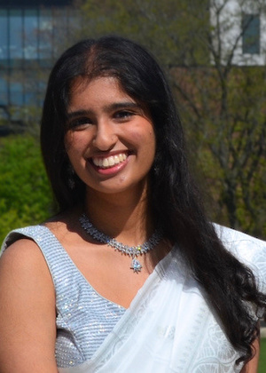 Headshot of Tania Mishra outdoors in a white saree.