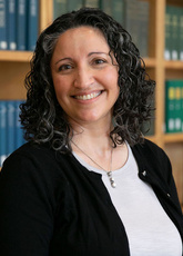 Nikki Roda stands in front of a bookcase