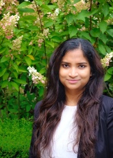 Headshot off Shriti smiling in a grassy area